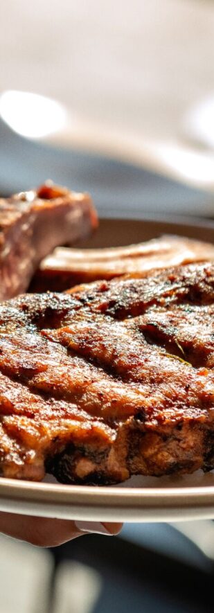 hands-serving-plate-of-asian-baby-back-ribs